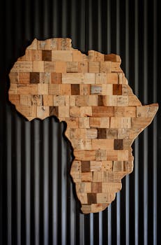 Artistic wooden map of Africa against dark corrugated background.